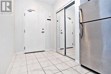 Barrie (Ardagh) condo for rent - A white tiled kitchen with a refrigerator and three doors.