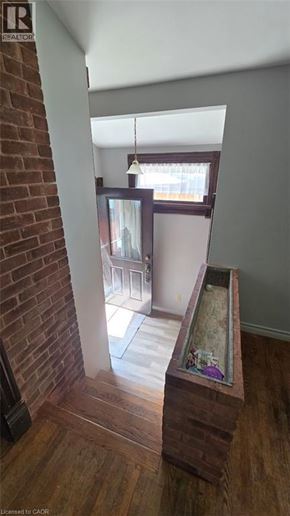 Listowel apartment for rent - A view down a hallway with a brick wall on the left and a window with blinds on the right.