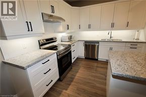 Seaforth townhouse for rent - A kitchen with white cabinets and a granite countertop.
