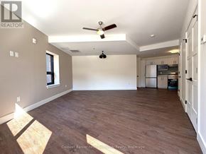 Arran-Elderslie townhouse for rent - A spacious room with wooden flooring and a ceiling fan.