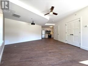 Arran-Elderslie townhouse for rent - A spacious room with a ceiling fan and a kitchen area in the background.