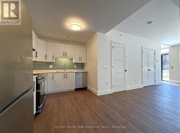 Arran-Elderslie townhouse for rent - A kitchen with white cabinets and a wooden floor.