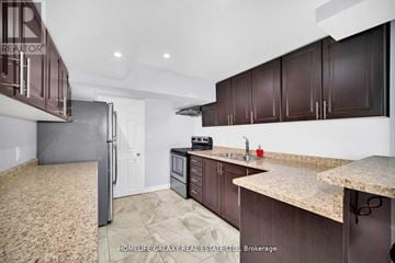 Ajax (Northeast Ajax) apartment for rent - A kitchen with brown cabinets and a granite countertop.
