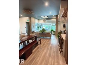 Edmonton apartment for rent - A long wooden table is in the middle of a room with a glass window.