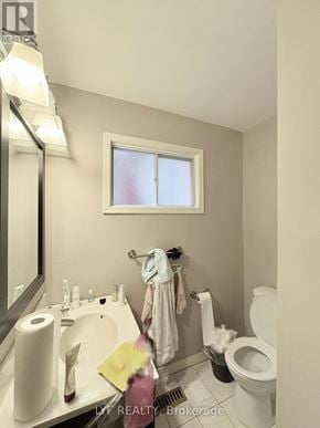 Markham (Unionville) apartment for rent - A bathroom with a toilet, sink, mirror, and towel.