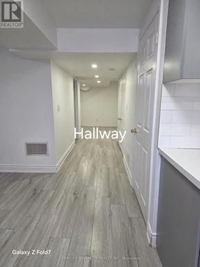 Vaughan (Maple) apartment for rent - A hallway with wood flooring and white walls.