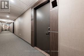Grimsby (Grimsby Beach) condo for rent - A hallway with a closed door and a brokerage logo on the wall.