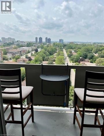 Waterloo condo for rent - Two chairs are placed on a balcony overlooking a cityscape.