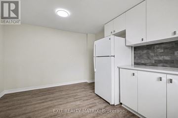 Ottawa townhouse for rent - A kitchen area with a refrigerator and cabinets.