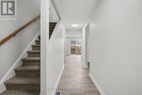 Ottawa townhouse for rent - A hallway with a staircase and a door at the end.