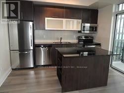 Toronto (Church-Yonge Corridor) condo for rent - A kitchen with a stainless steel refrigerator and a wooden island.