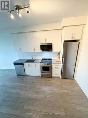 Hamilton (Beasley) condo for rent - A kitchen with white cabinets and a wooden floor.