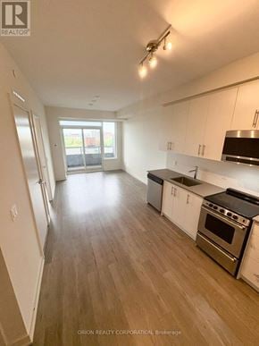 Hamilton (Beasley) condo for rent - A kitchen with white cabinets and a black stove top oven.