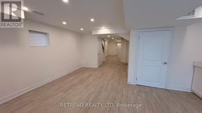 Vaughan (Patterson) apartment for rent - A spacious room with light wood flooring and white walls, with a door on the right side.