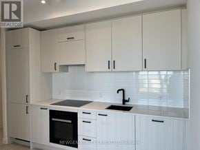 Toronto (Banbury-Don Mills) condo for rent - A kitchen with white cabinets and a black sink.