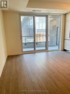 Toronto (Waterfront Communities) condo for rent - A room with wooden flooring and a sliding glass door.
