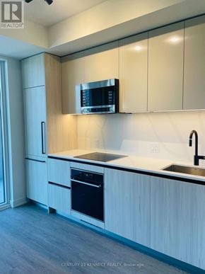 Toronto (Waterfront Communities) condo for rent - A kitchen with a black microwave above the stove.