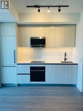 Toronto (Waterfront Communities) condo for rent - A kitchen with white cabinets and a black stove top oven.