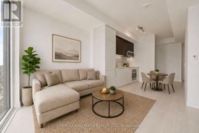 Toronto (Church-Yonge Corridor) condo for rent - A living room with a beige sofa, a coffee table, and a dining table with chairs.