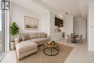 Toronto (Church-Yonge Corridor) condo for rent - A living room with a beige sofa, a coffee table, and a dining table with chairs.