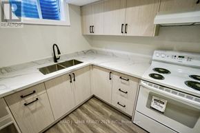 Vaughan (East Woodbridge) apartment for rent - A kitchen with a stove, sink, and cabinets.