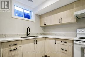 Vaughan (East Woodbridge) apartment for rent - A kitchen with wooden cabinets and a marble countertop.