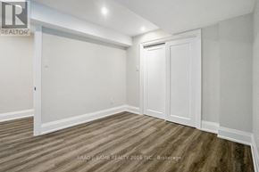 Vaughan (East Woodbridge) apartment for rent - A room with white walls and wood flooring, with a door on the right.