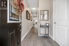 Brampton (Bram West) apartment for rent - A hallway with a table and chairs in the middle.