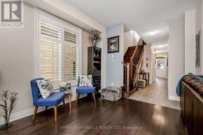 Brampton (Bram West) apartment for rent - A living room with a blue chair and a wooden floor.