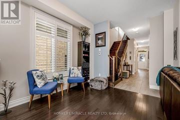 Brampton (Bram West) apartment for rent - A living room with a blue chair and a wooden floor.