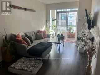 Toronto (High Park-Swansea) condo for rent - A living room with a grey couch and a black ottoman.