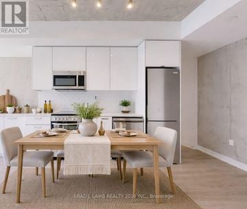 Toronto (Moss Park) condo for rent - A modern kitchen with a dining table set for two.