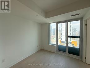 Toronto (Church-Yonge Corridor) condo for rent - A room with a large window overlooking a cityscape.