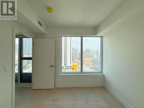 Toronto (Church-Yonge Corridor) condo for rent - A room with a large window overlooking a cityscape.