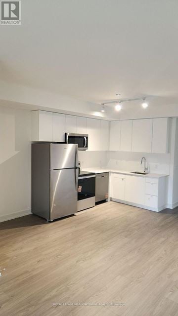 St. Catharines (E. Chester) townhouse for rent - A modern kitchen with a stainless steel refrigerator and white cabinets.