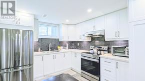 Whitchurch-Stouffville (Stouffville) apartment for rent - A modern kitchen with white cabinets and stainless steel appliances.