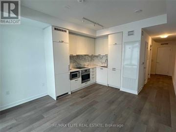 Vaughan (Concord) condo for rent - A kitchen with white cabinets and a marble backsplash.