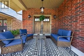 Collingwood apartment for rent - A patio with a wicker chair and a table with a plant on it.
