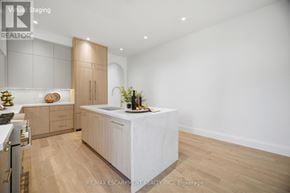 Mississauga (Port Credit) apartment for rent - A modern kitchen with wooden floors and white walls.
