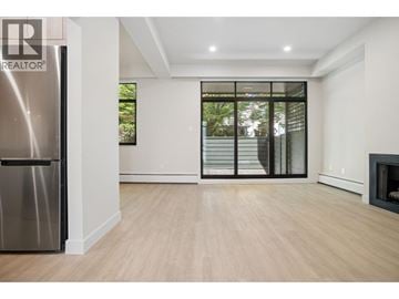 Vancouver townhouse for rent - A modern kitchen with a stainless steel refrigerator and wooden flooring.