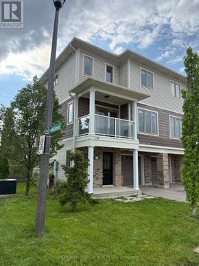 St. Catharines (Secord Woods) townhouse for rent - A modern two-story house with a balcony and a garage door.