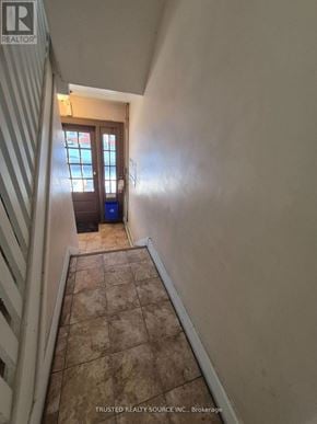 Windsor multi-family for rent - A hallway with a tiled floor and a door at the end.