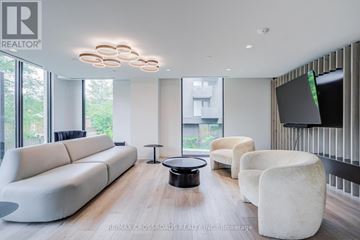 Toronto (Clanton Park) condo for rent - A modern living room with a white sofa and a black coffee table.