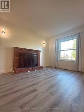Niagara Falls (Cherrywood) multi-family for rent - A living room with a fireplace and a large window.