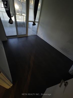 Toronto (Niagara) condo for rent - A room with a dark floor and a glass door.
