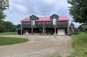 Shelburne apartment for rent - A barn with a red roof and white trim is surrounded by a gravel driveway.