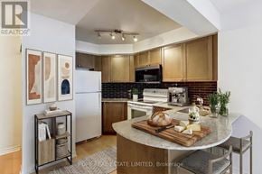 Toronto (Bay Street Corridor) condo for rent - A kitchen with wooden cabinets and a black microwave.