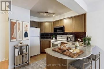 Toronto (Bay Street Corridor) condo for rent - A kitchen with wooden cabinets and a black microwave.