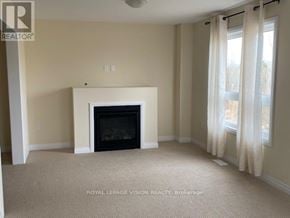 Kawartha Lakes (Lindsay) apartment for rent - A living room with a fireplace and carpeted floor.