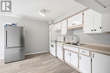 Waterloo duplex for rent - A kitchen with white cabinets and a stainless steel refrigerator.
